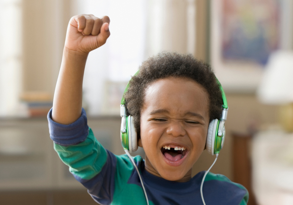کودک در حال گوش دادن به موسیقی با هدفون